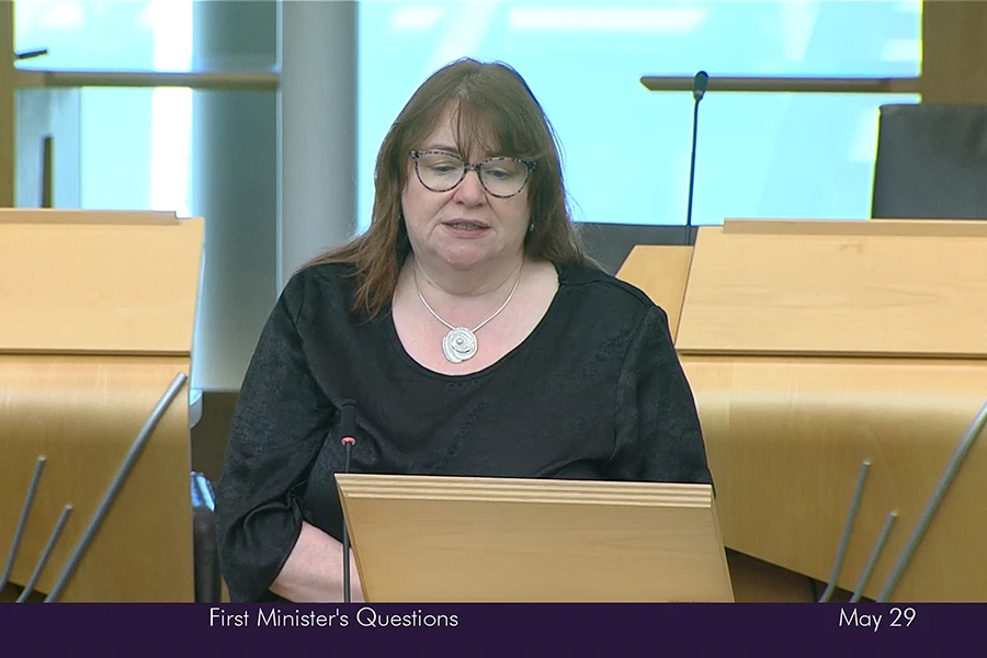 Clare Adamson MSP speaking at a podium during First Minister’s Questions in the Scottish Parliament